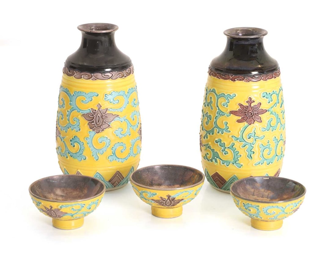 A pair of Japanese porcelain sake bottles, early 20th century,: A pair of Japanese porcelain sake bottles, early 20th century, each with green scrolled motifs to a yellow ground, six-character mark, together with three conforming sake cups, with metal interiors