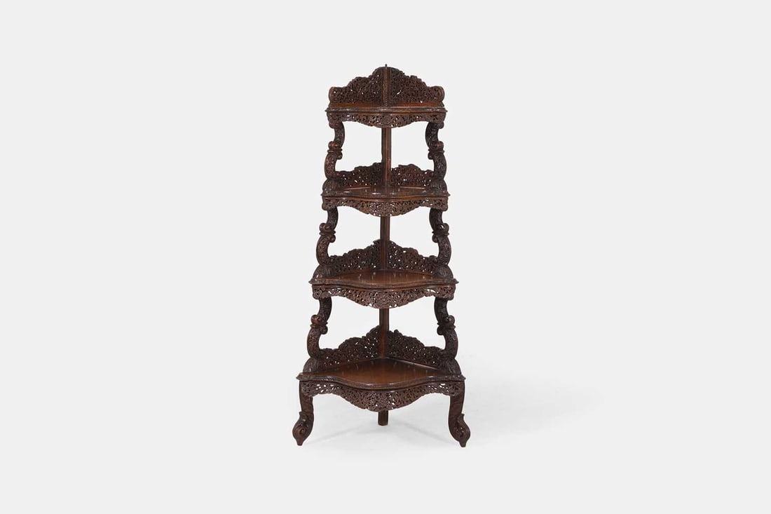 An Anglo-Indian hardwood corner étagère, late 19th century,: An Anglo-Indian hardwood corner étagère, late 19th century, the four graduated serpentine shelves, with carved and pierced foliate supports and gallery borders, raised on scrolling feet 64cm