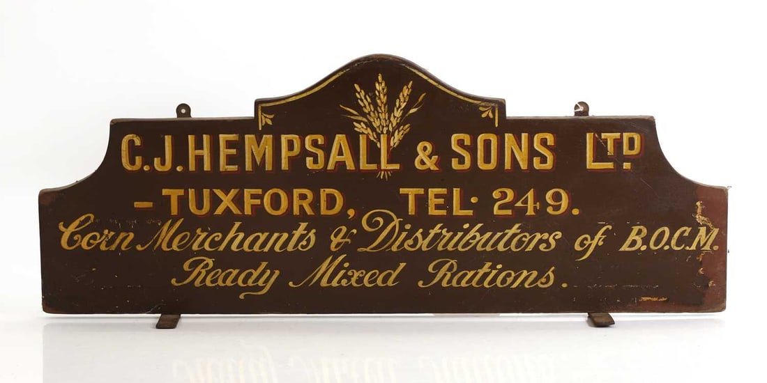 A Victorian corn merchants sign,: A Victorian corn merchants sign, inscribed ‘C.J. Hempsall & Sons Ltd, - TUXFORD, TEL.249' 68cm wide, 26cm high Condition Report: Some flaking to the paint and decoration. Scuff to the