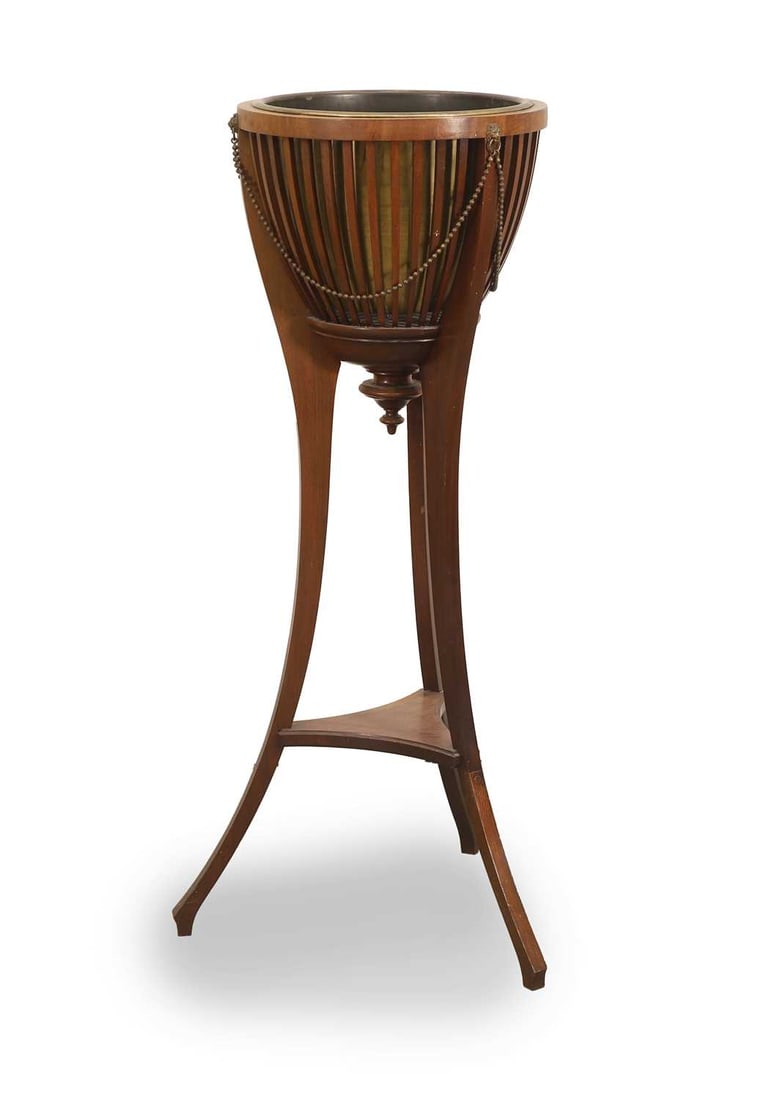 An Edwardian mahogany jardinière, early 20th century,: An Edwardian mahogany jardinière, early 20th century, the tripod base united by a platform stretcher, the top reserve decorated with beadwork and lion mask mounts 47cm wide, 96.5cm high