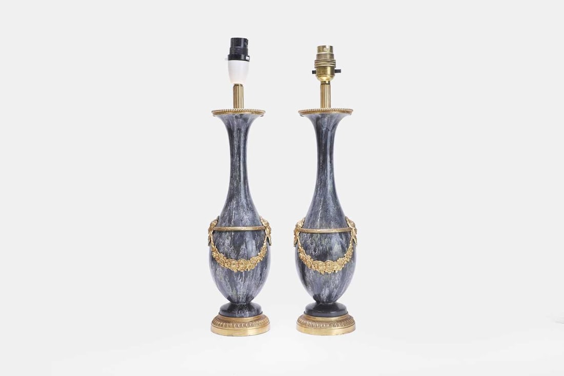A pair of Louis XVI-style ceramic and gilt-metal-mounted table lamps, 20th century,: A pair of Louis XVI-style ceramic and gilt-metal-mounted table lamps, 20th century, each of slender baluster form with mottled glaze, mounted with gilt-metal mask and foliate swags, and raised on a