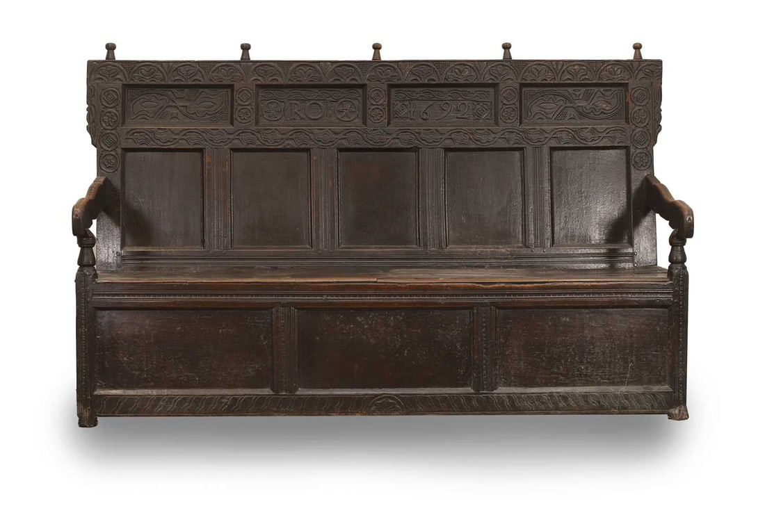 A carved oak settle, 18th century,: A carved oak settle, 18th century, dated to one of the top panels '1682' and initialled 'R.O' 188cm wide, 65cm deep, 111cm high Condition Report: Some areas of possible previous damp. Some knocks to