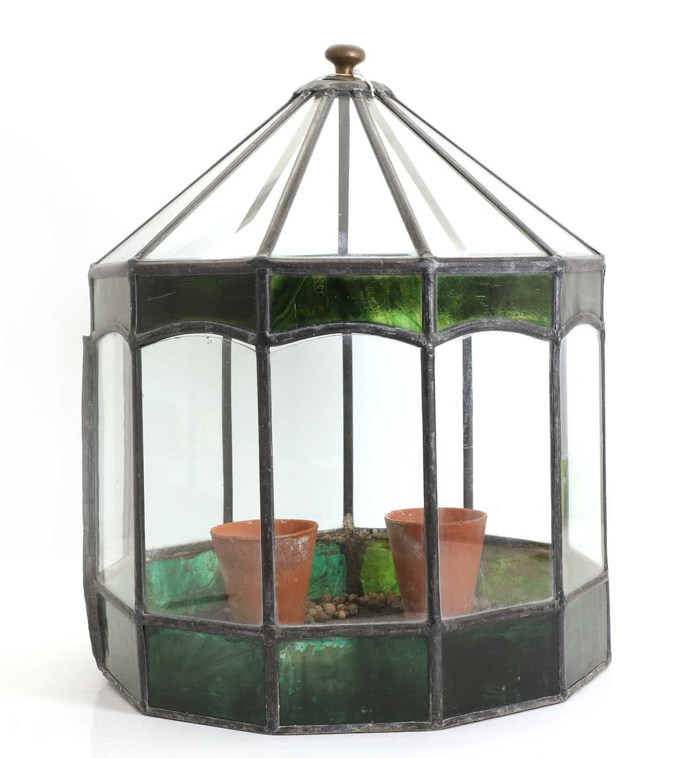 A lead and glass terrarium, 20th century,: A lead and glass terrarium, 20th century, eleven-sided, with green-tinted glass panels, one sliding to access the interior 32cm diameter, 45cm high Condition Report: with two small terracotta pots