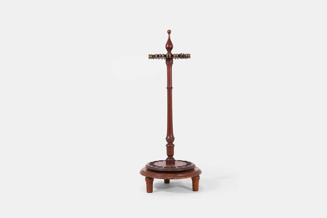 A snooker cue stand, 20th century,: A snooker cue stand, 20th century, comprising eighteen cue holders, the rotating turned stem on a raised circular base, surmounted by a bulbous finial 49cm base diameter, 122cm high