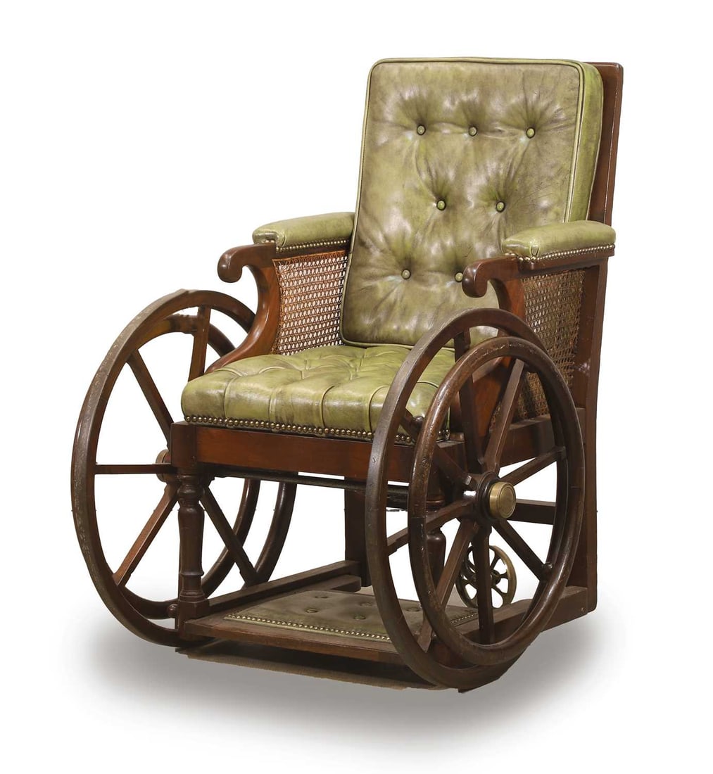 A mahogany and studded leather invalid chair, late 19th to early 20th century,: A mahogany and studded leather invalid chair, late 19th to early 20th century, with fold out footrest, brass detailing, and central brass rear castor 70cm wide, 80cm deep, 99cm high Condition Report: