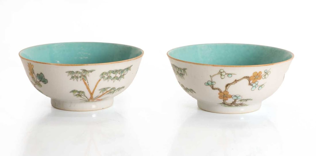 A pair of Chinese enamelled teabowls,: A pair of Chinese enamelled teabowls, each decorated with bamboo trees, chrysanthemum and flowering foliage, in the interiors with a turquoise ground, with an iron-red four character seal mark to