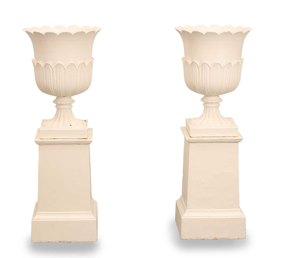 A pair of cast iron painted urns and stands: A pair of cast iron painted urns and stands each with petalled rims, raised on a tapering plinth 25cm wide, 25cm deep, 80cm high, each 30cm diameter 4 Condition Report: Repainted. Some wear.