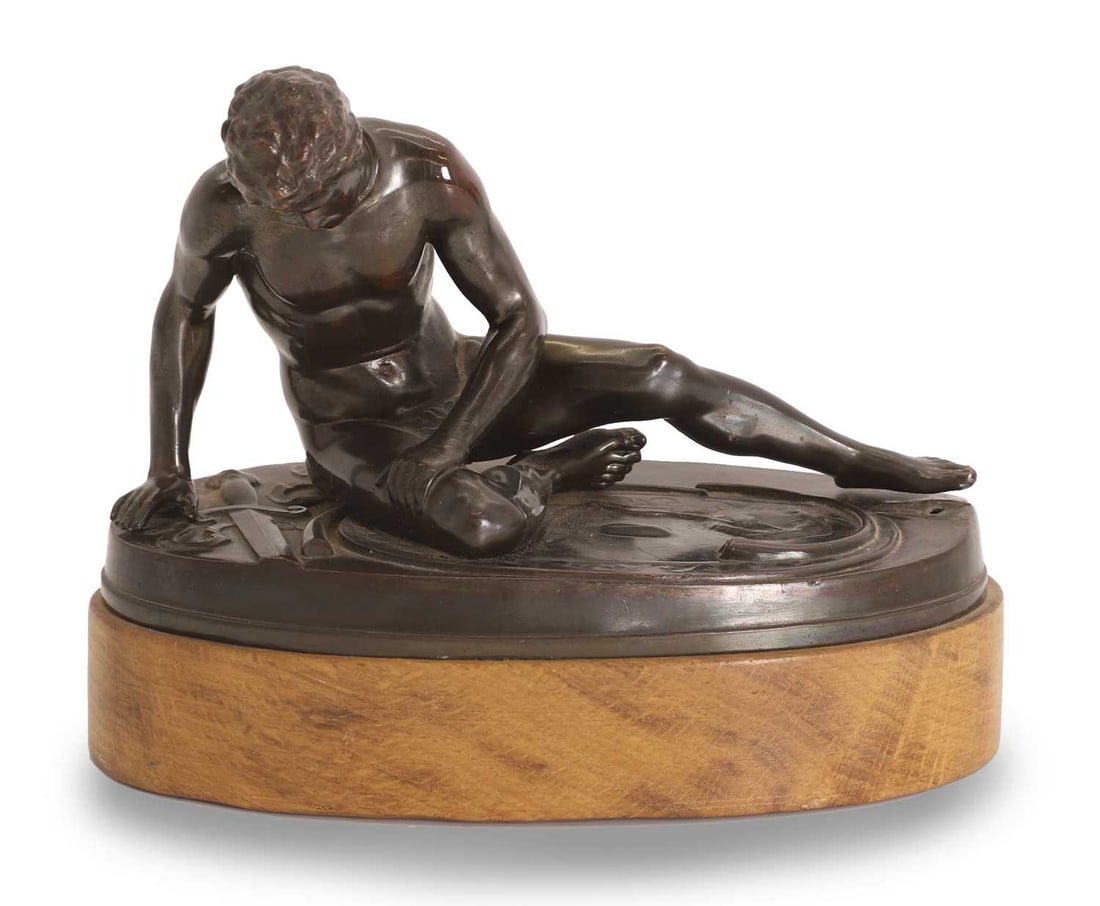 A pressed bronzed tin figure, 20th century,: A pressed bronzed tin figure, 20th century, bronzed modelled after the antique, The Dying Gaul, on wooden plinth base 18cm wide, 14cm high Condition Report: It has been repinned, with repairs to the