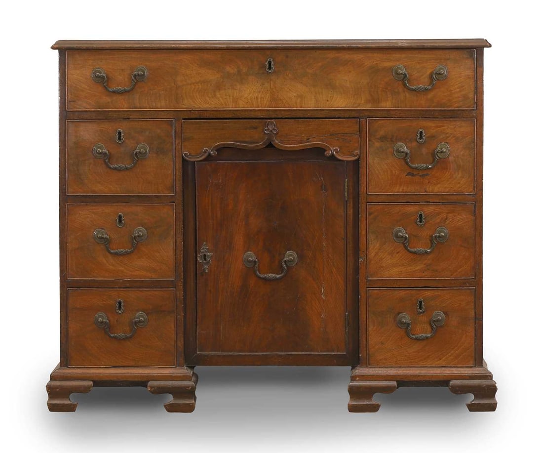 A George III mahogany kneehole desk, circa 1770,: A George III mahogany kneehole desk, circa 1770, with a central cupboard, on ogee bracket feet 92cm wide, 52cm, 79.5cm high Condition Report: marks knocks and losses, sun fading and restorations to