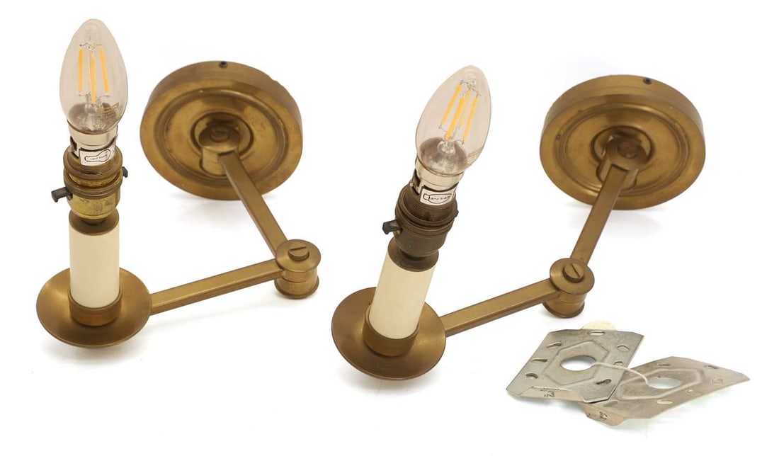 A pair of brass library wall lights, 20th century,: A pair of brass library wall lights, 20th century, for wall or furniture mounting, with adjustable arms 33cm wide, 21cm high, to the fitting 2 Condition Report: Scuff marks near the base and some