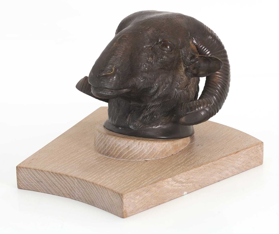 A cast bronze ram’s head, 20th century: A cast bronze ram’s head, 20th century with chased detailing, mounted to a limed oak board, 24cm wide on board Condition Report: The rams head is loose and not attached to the board