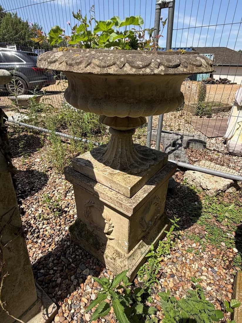 A blush terracotta urn on plinth, 20th century,: A blush terracotta urn on plinth, 20th century, the plinth base cast with laurel wreath 55cm wide, 105cm high Provenance: The contents of Thornton House, Clare.