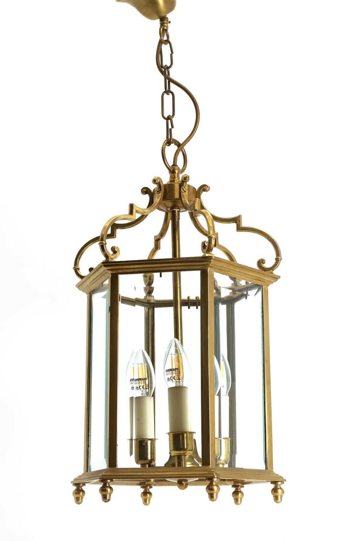 A brass ceiling lantern, 20th century,: A brass ceiling lantern, 20th century, with hanging chain, and shaped supports, fitted for electricity 30cm wide, 51cm high