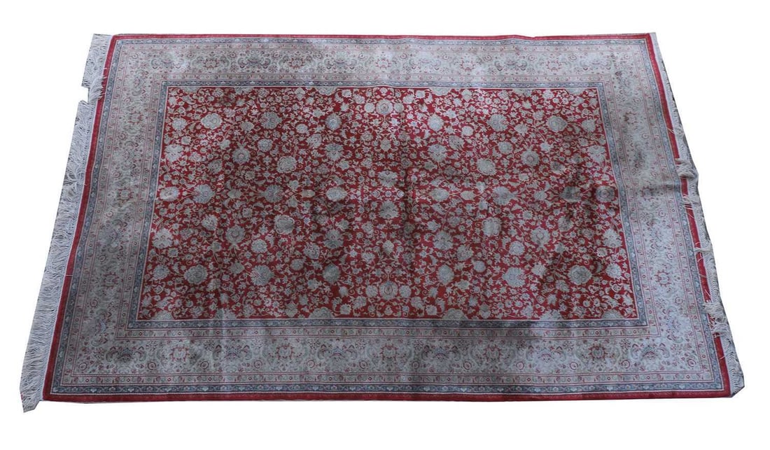 A Persian silk style rug,: A Persian silk style rug, with a red central ground and floral ivory border 195 x 117cm Condition Report: Faux silk. Some staining to the surface