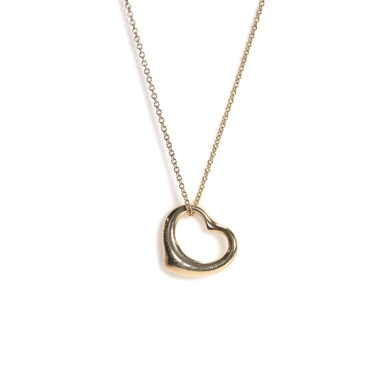 Elsa Peretti for Tiffany & Co., an 18ct gold open heart pendant necklace,: Elsa Peretti for Tiffany & Co., an 18ct gold open heart pendant necklace, the solid open heart, marked 750, Spain, signed 'Tiffany & Co. © Elsa Peretti', suspended by an 18ct gold trace link chai