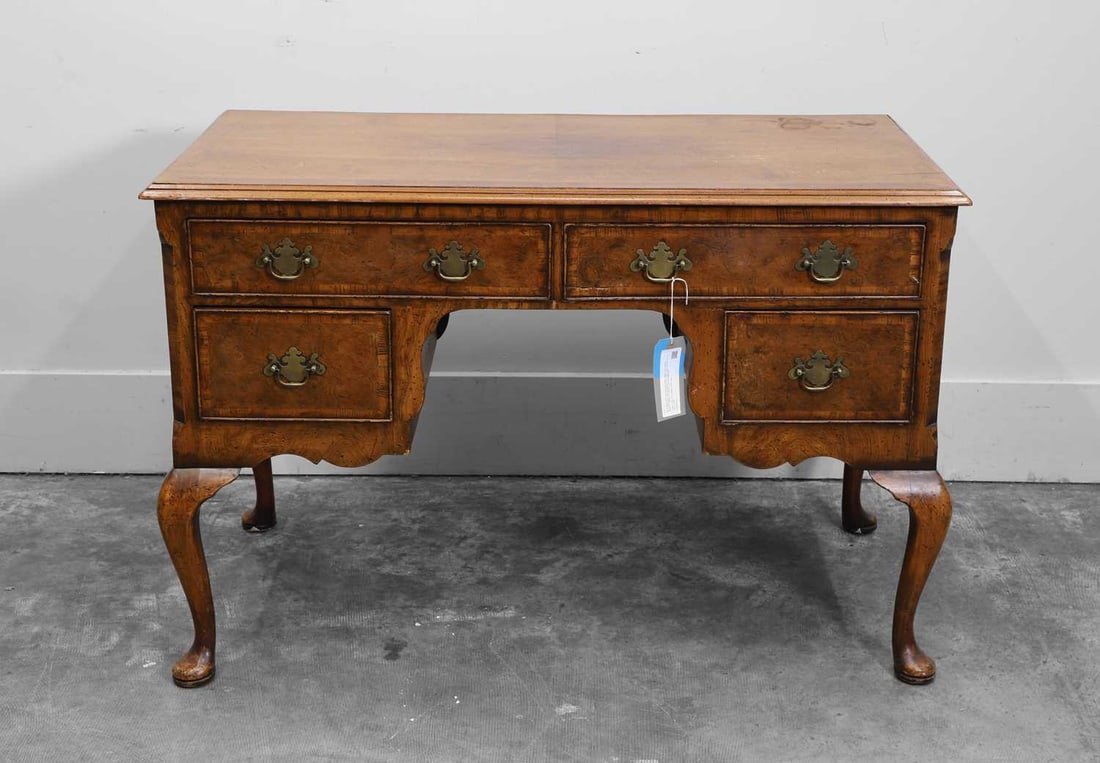A George I style walnut writing table, early 20th century,: A George I style walnut writing table, early 20th century, the rectangular cross banded top over two long and two short drawers, raised on cabriole legs and pad feet 116cm wide, 62cm deep, 78cm high