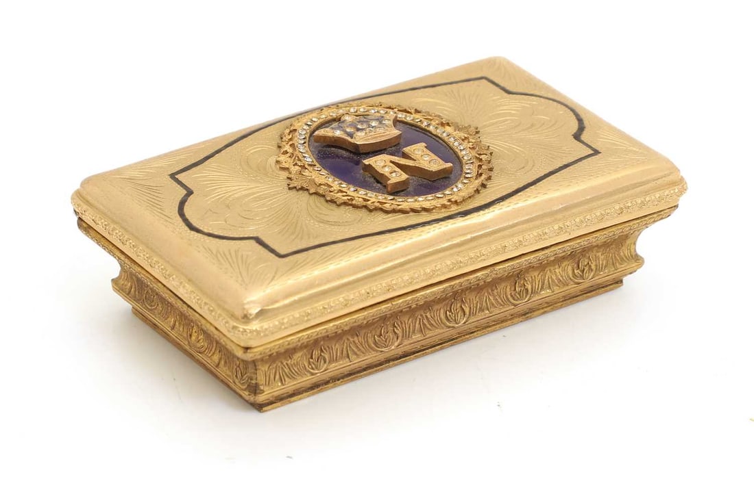 A Napoleon III gilt brass guilloché enamel and jewelled snuff box, 19th century,: A Napoleon III gilt brass guilloché enamel and jewelled snuff box, 19th century, with raised 'N' and crown on the cover, over a blue enamelled oval cartouche 9.5cm wide,