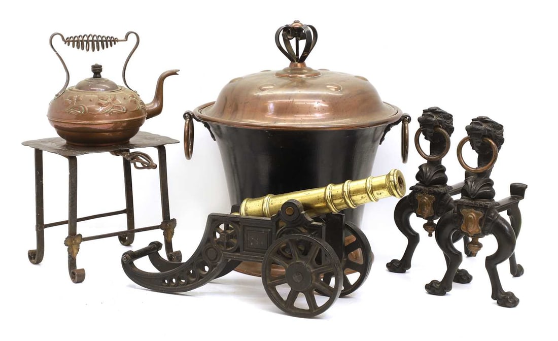 An Arts and Crafts copper and enamelled coal bin and cover, circa 1900,: An Arts and Crafts copper and enamelled coal bin and cover, circa 1900, a pair of fire dogs, a brass and cast iron model cannon, a trivet and a kettle coal, 36cm diameter, cannon, 46cm long 6 Conditio