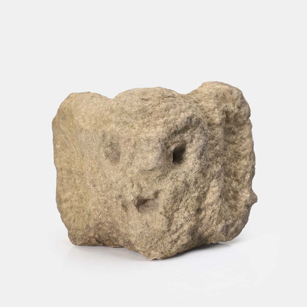 A sandstone carved corbel gargoyle head, possibly medieval,: A sandstone carved corbel gargoyle head, possibly medieval, naively carved (28cm wide, 15cm deep, 23cm high) Condition Report: general signs of age, few small chips to base