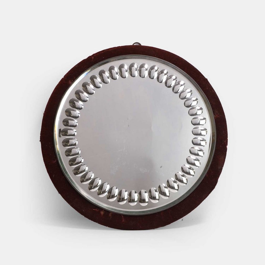 A Victorian sorcerer's mirror, late 19th century,: A Victorian sorcerer's mirror, late 19th century, with a bevelled edge and forty cut oval discs, with a maroon velvet frame (36cm diameter) Condition Report: Very minor spots of foxing to glass, velve