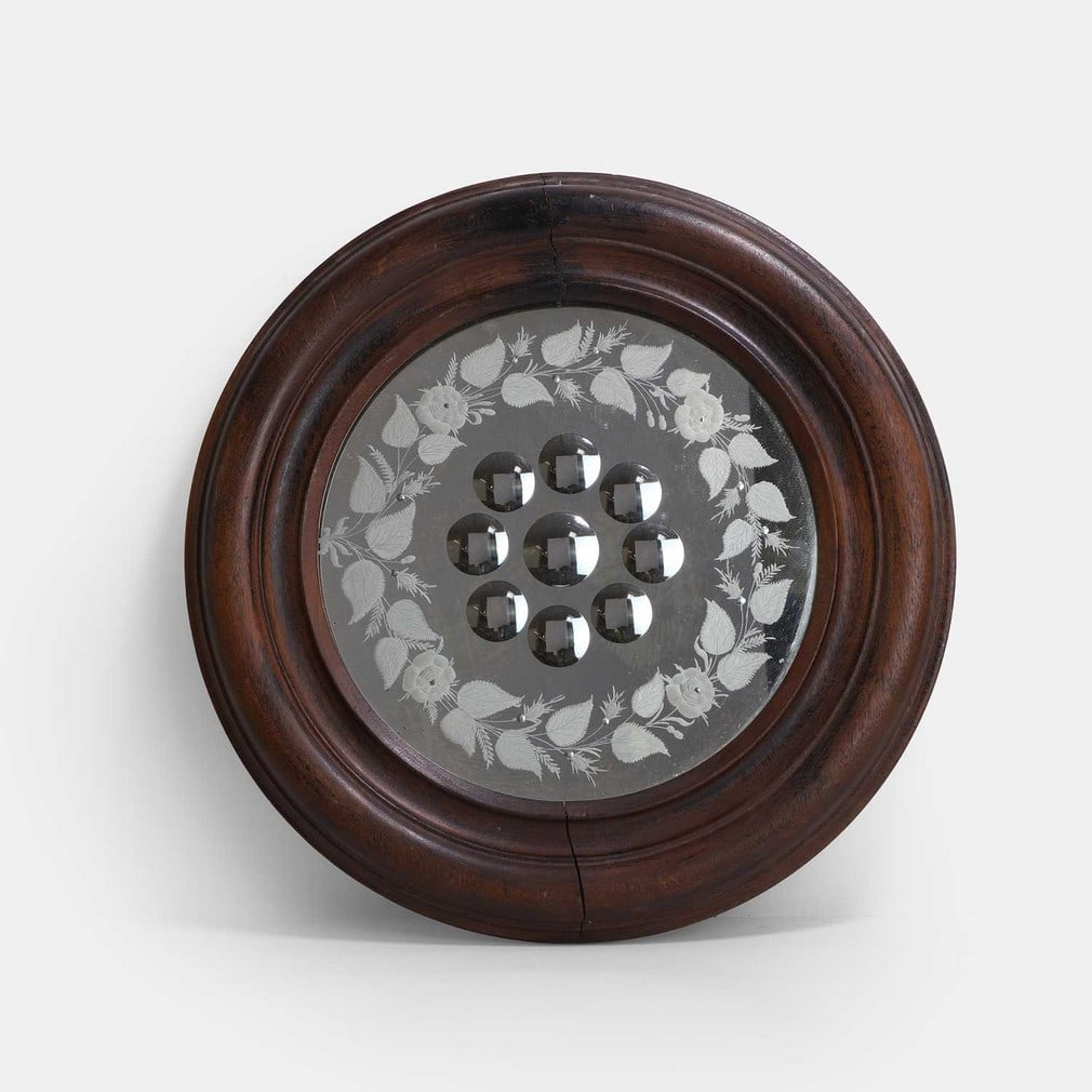 A Victorian sorcerer's mirror, late 19th century,: A Victorian sorcerer's mirror, late 19th century, with nine cut-glass roundels, bordered with etched foliage and further smaller cut roundels, within a mahogany frame (44.5cm diameter) Condition Repor
