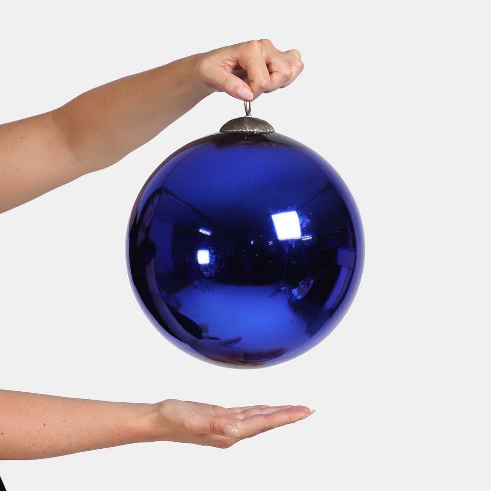 A large cobalt-blue witch's ball, late 19th century,: A large cobalt-blue witch's ball, late 19th century, with an embossed cap and ring suspension (25cm diameter) Condition Report: Darkening to silver in some places, particularly at the bottom.