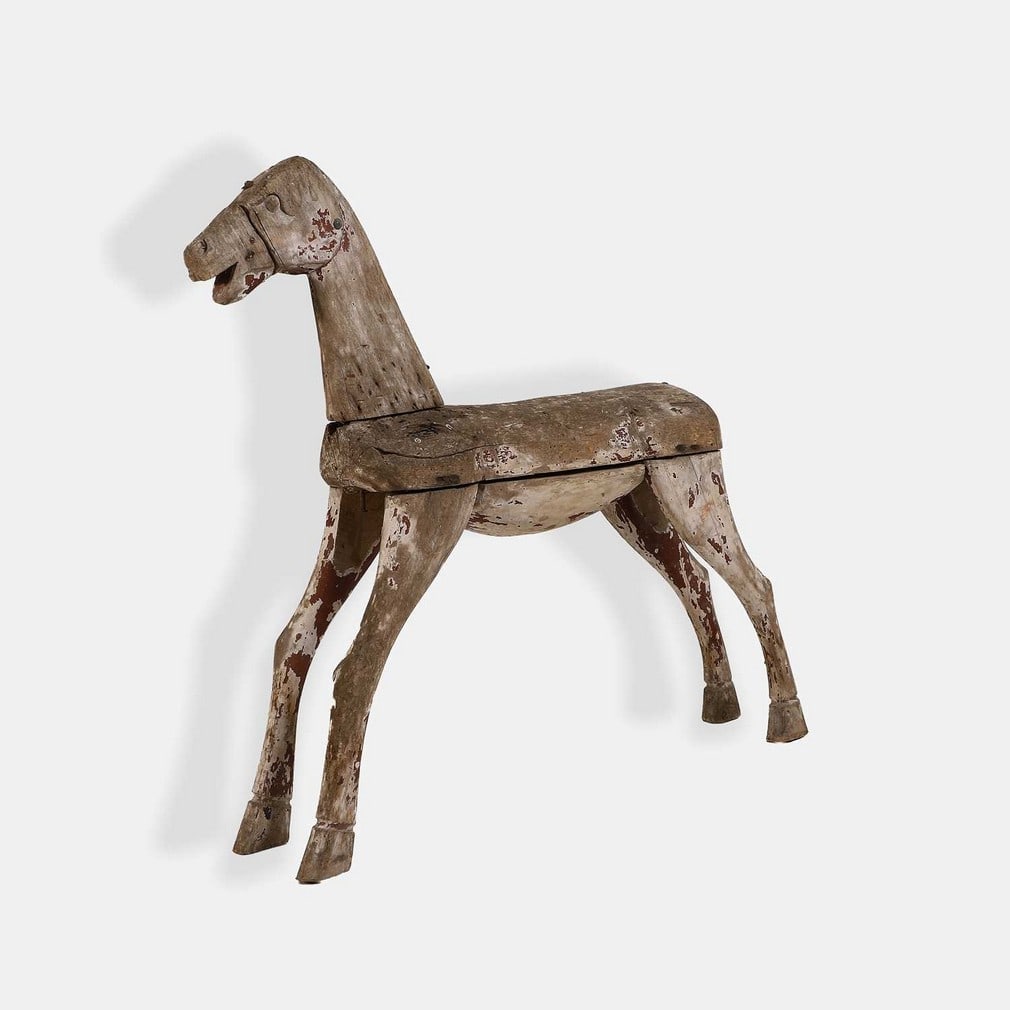 A carved wood horse, 19th century, French,: A carved wood horse, 19th century, French, with remnants of paint (80cm wide, 15cm deep, 74cm high) Condition Report: Worn.