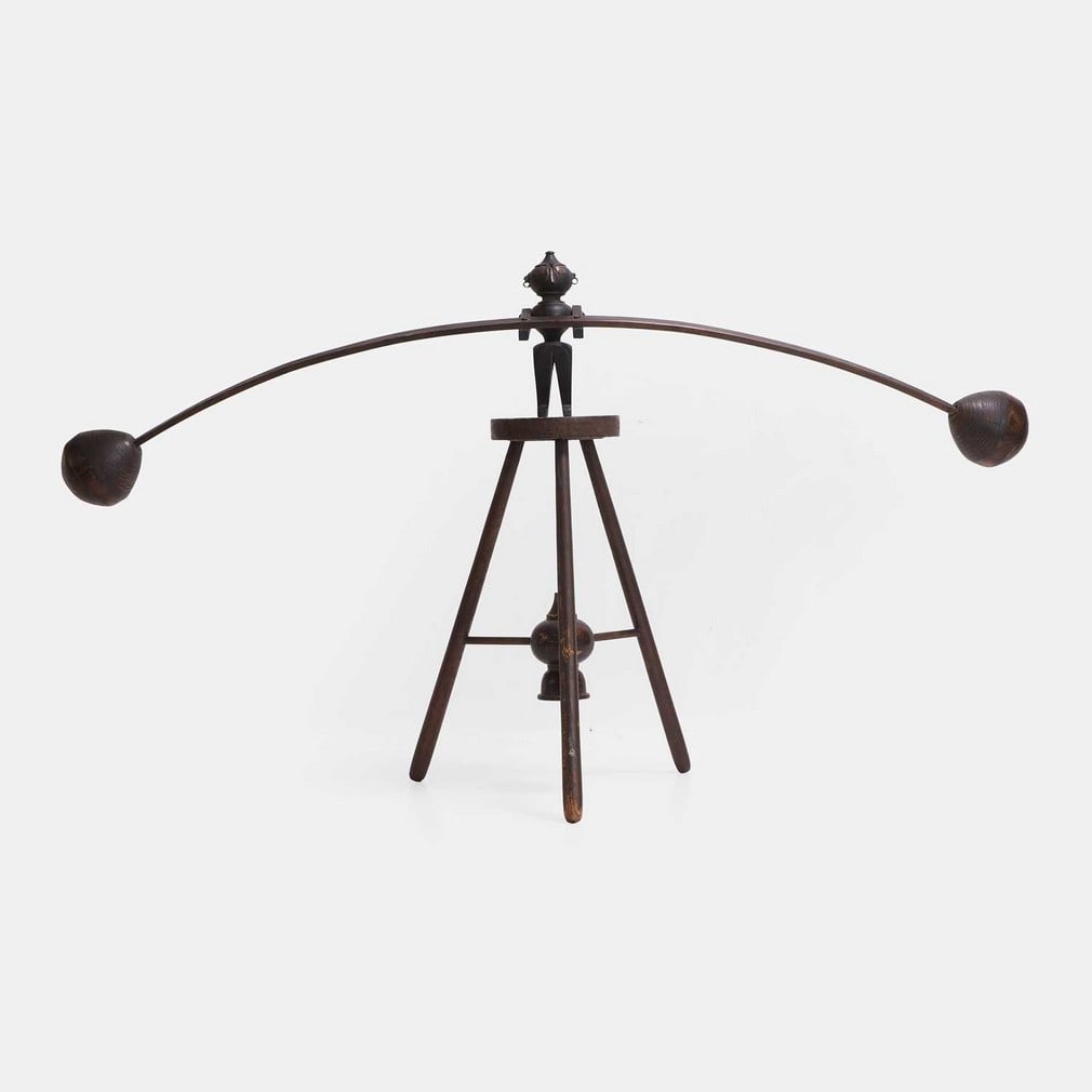A wood and metal-mounted trapeze toy, circa 1900, probably Siamese,: A wood and metal-mounted trapeze toy, circa 1900, probably Siamese, the trapeze artist with pierced ears, metal eyes and nose, and hinged arms and legs, supporting a long balancing pole with bulb term