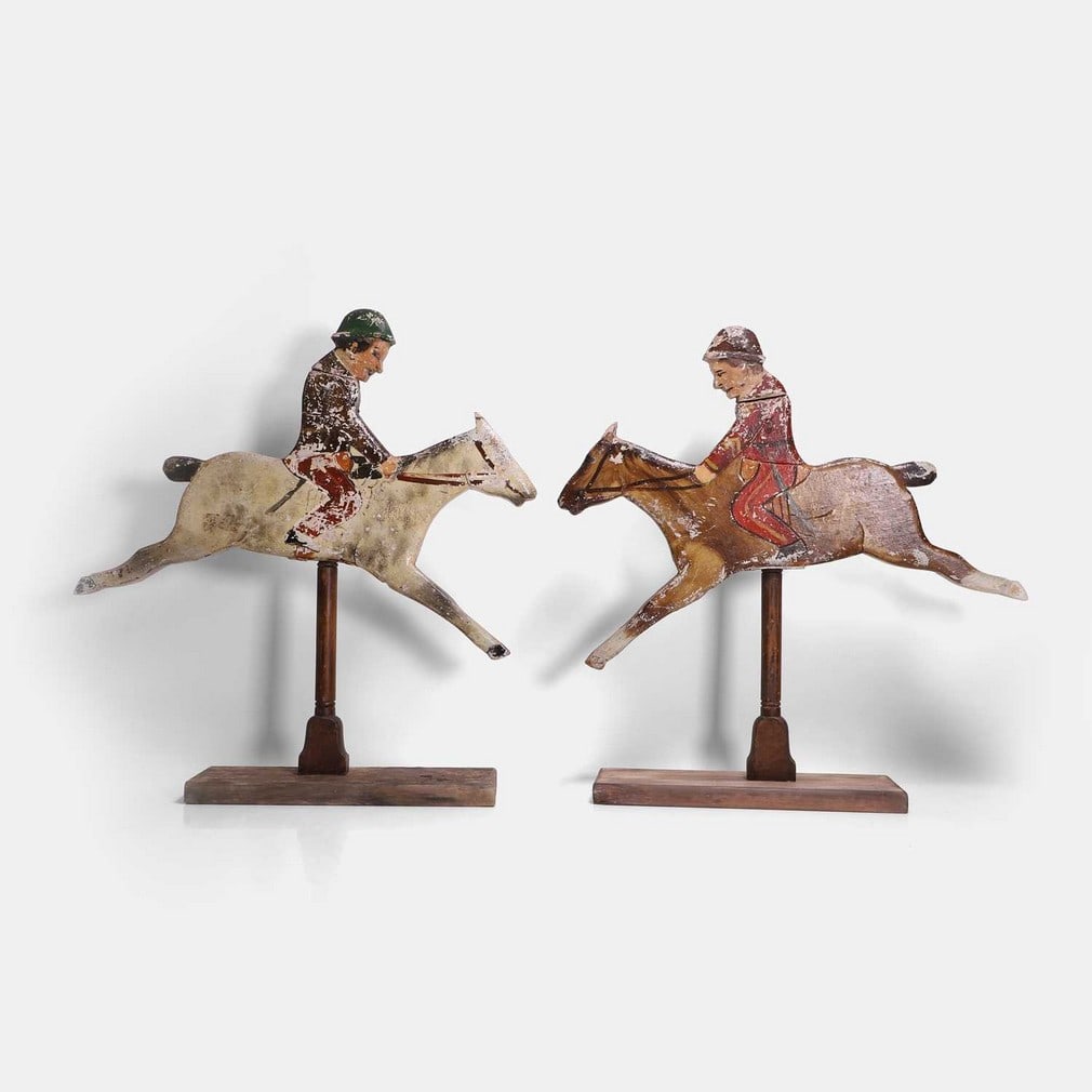 A pair of folk art 'knock down jockeys' parlour game, circa 1900,: A pair of folk art 'knock down jockeys' parlour game, circa 1900, each fret-cut and painted, with hinged heads, on turned supports and later plinths (largest 45cm wide, 11.5cm deep, 50.5cm high) (2) C