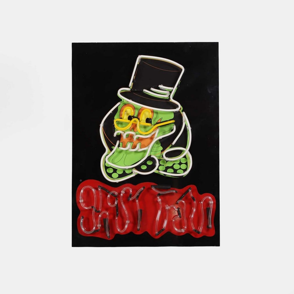 A 'Ghost Train' neon sign, modern, by Adam Turner of Derbyshire Neons,: A 'Ghost Train' neon sign, modern, by Adam Turner of Derbyshire Neons, the backboard printed with a skull wearing glasses and a hat, and with neon tubes (88.5 x 63.5cm)