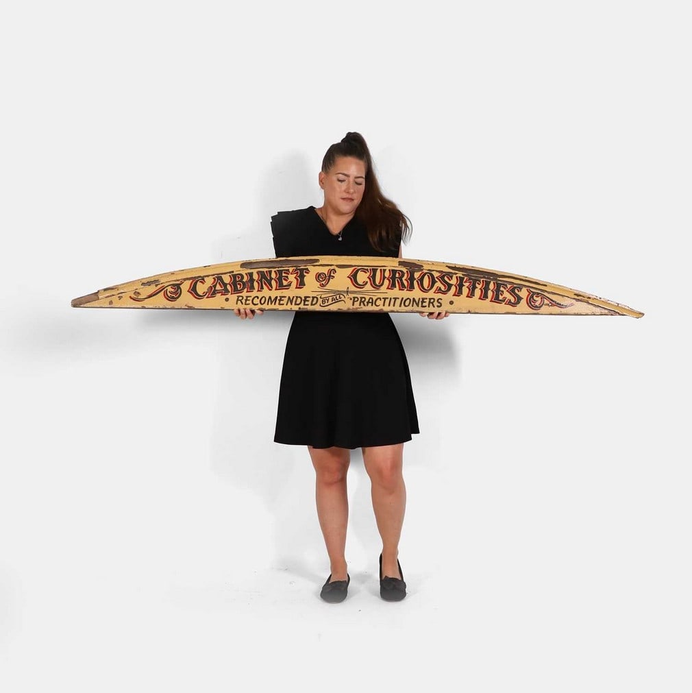 A large 'Cabinet of Curiosities' sign, late 20th century,: A large 'Cabinet of Curiosities' sign, late 20th century, arched and painted 'Cabinet of Curiosities Recommended by all Practitioners' (18 x 185cm) Condition Report: With losses to paint and the top m