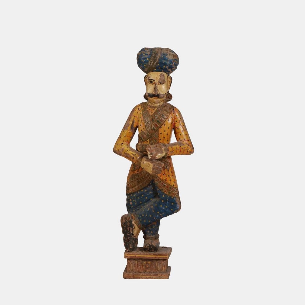 A carved and painted shop display figure, circa 1920s, Indian,: A carved and painted shop display figure, circa 1920s, Indian, modelled as a turbaned figure, his hands clasped, wearing brightly coloured clothes (42cm wide, 26cm deep, 122cm high) Condition Report: 