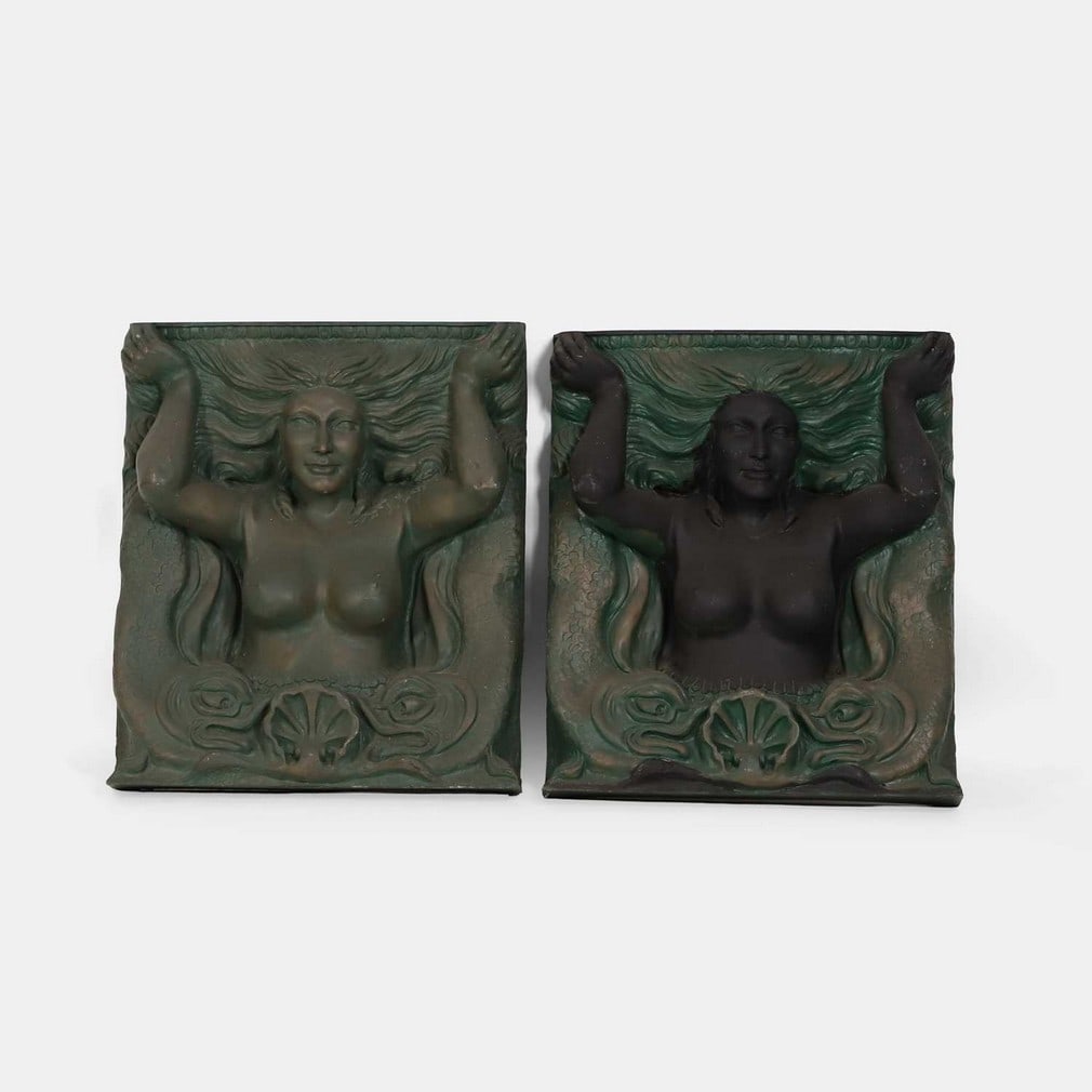 A pair of mermaid panels, 20th century,: A pair of mermaid panels, 20th century, resin casts, with a simulated bronze patina (65cm wide, 15.5cm deep, 76cm high) (2) Footnote: Taken from the outside of a Seamen's Mission in Liverpool, now dem