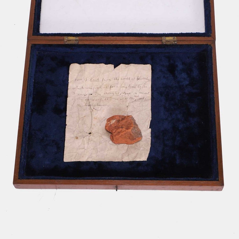 Of Waterloo interest: a red brick fragment circa 1815,: Of Waterloo interest: a red brick fragment circa 1815, with a handwritten pen and ink sheet, inscribed 'Piece of Brick from the Wall at Waterloo, which was fired at for a long time by the French, they