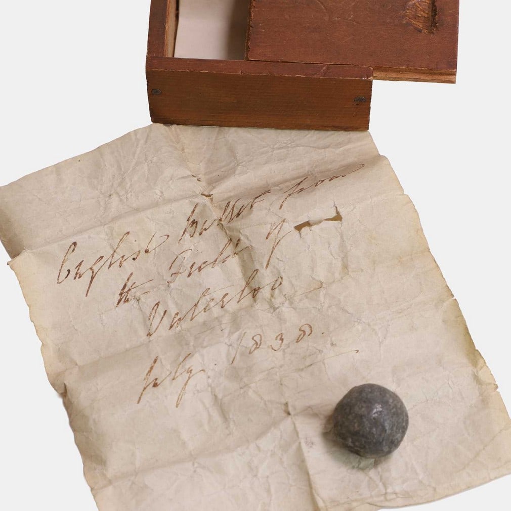 A lead shot from the Battle of Waterloo, early 19th century,: A lead shot from the Battle of Waterloo, early 19th century, with a label inscribed 'English bullet from the field of Waterloo, July 1830', in a wooden box (1.2cm diameter; box 12cm wide, 10cm deep) (