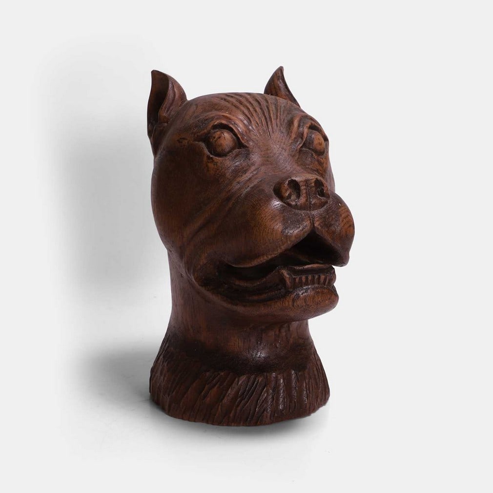 A carved oak bulldog's head, circa 1920,: A carved oak bulldog's head, circa 1920, characterfully modelled (15cm wide, 23cm deep, 29cm high) Condition Report: Some colour change. Some wear and minor splits to the wood. Both ears with chips.