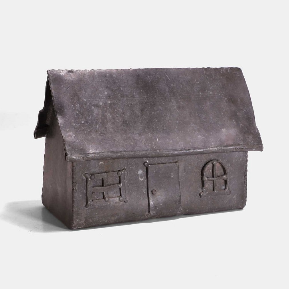 A folk art lead model of a house, early 20th century,: A folk art lead model of a house, early 20th century, the front applied with a door and two windows (23.5cm wide, 12.5cm deep, 15.5cm high) Condition Report: Minor knocks and dents.