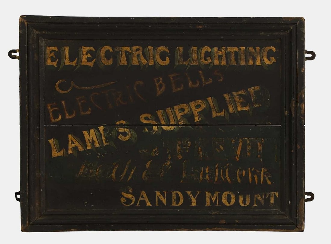 A folk art 'Electric Lighting' painted wooden sign, early 20th century,: A folk art 'Electric Lighting' painted wooden sign, early 20th century, painted 'Electric Lighting/Electric Bells/Lamps Supplied...Sandymount', within a moulded frame (43 x 53.5cm overall) Condition R