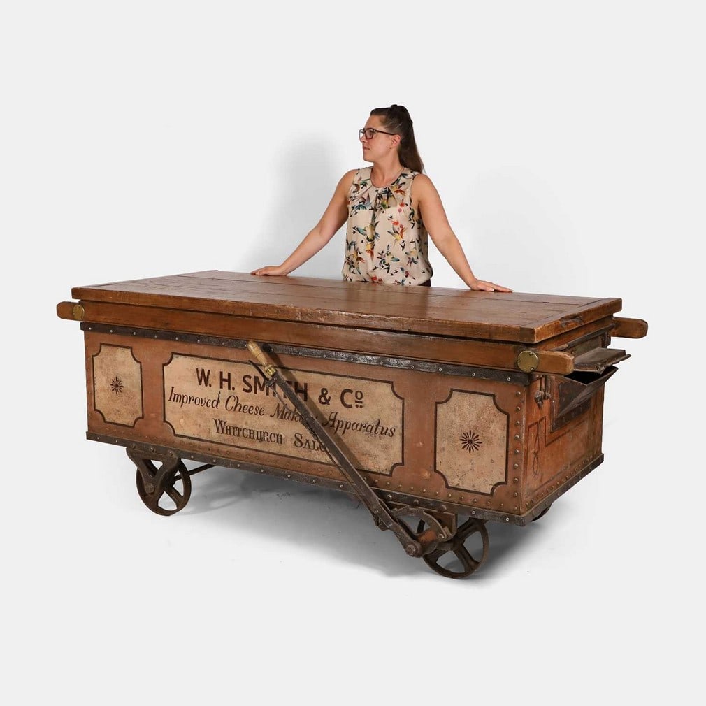 A Victorian railway freight truck, late 19th century and later, used to transport feed to local: A Victorian railway freight truck, late 19th century and later, used to transport feed to local dairies, with a solid oak top, original wheels and tilt lever, with later painted 'W H Smith & Co Improv