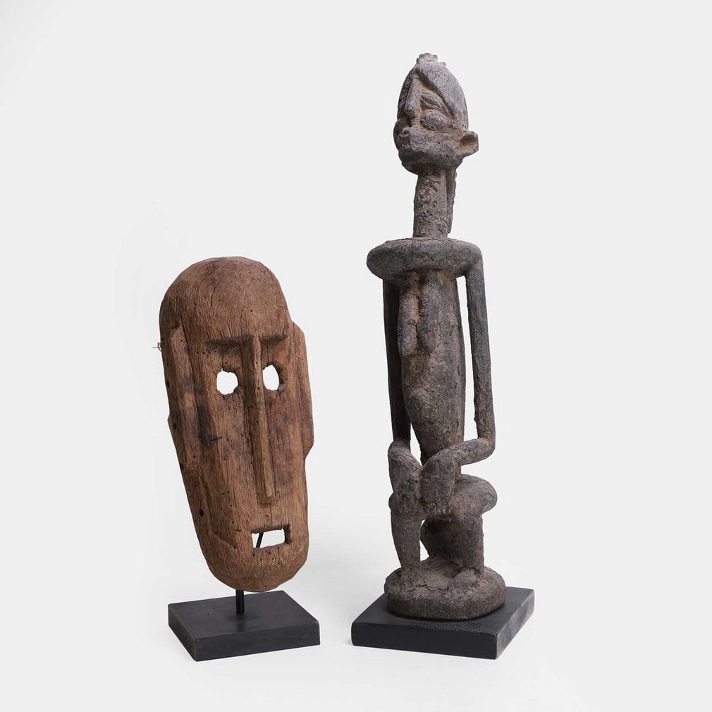 Two African tribal carved wood sculptures, 20th century,: Two African tribal carved wood sculptures, 20th century, a Dogon ritual figure statue, raised on an ebonised plinth, and a Bamana mask, probably Dogon, Mali, on a modern stand, (Dogon, 14cm wide,