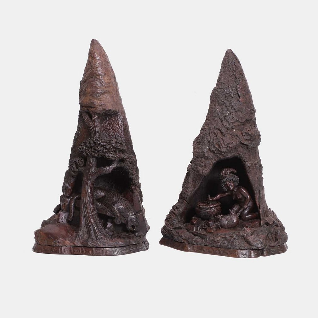 A fine pair of 'root' carvings, early 20th century, South American,: A fine pair of 'root' carvings, early 20th century, South American, each carved with a cave, one with an indigenous woman holding an armadillo and a cooking pot, the other with a leopard beneath a