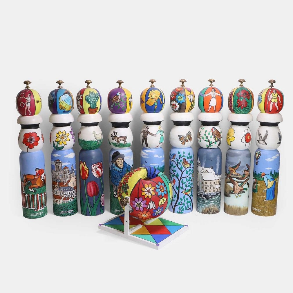 A set of nine folk art skittles, 20th century, French,: A set of nine folk art skittles, 20th century, French, each painted differently, the lower sections with a band of figures, animals and birds in landscapes, the upper sections with various motifs of f