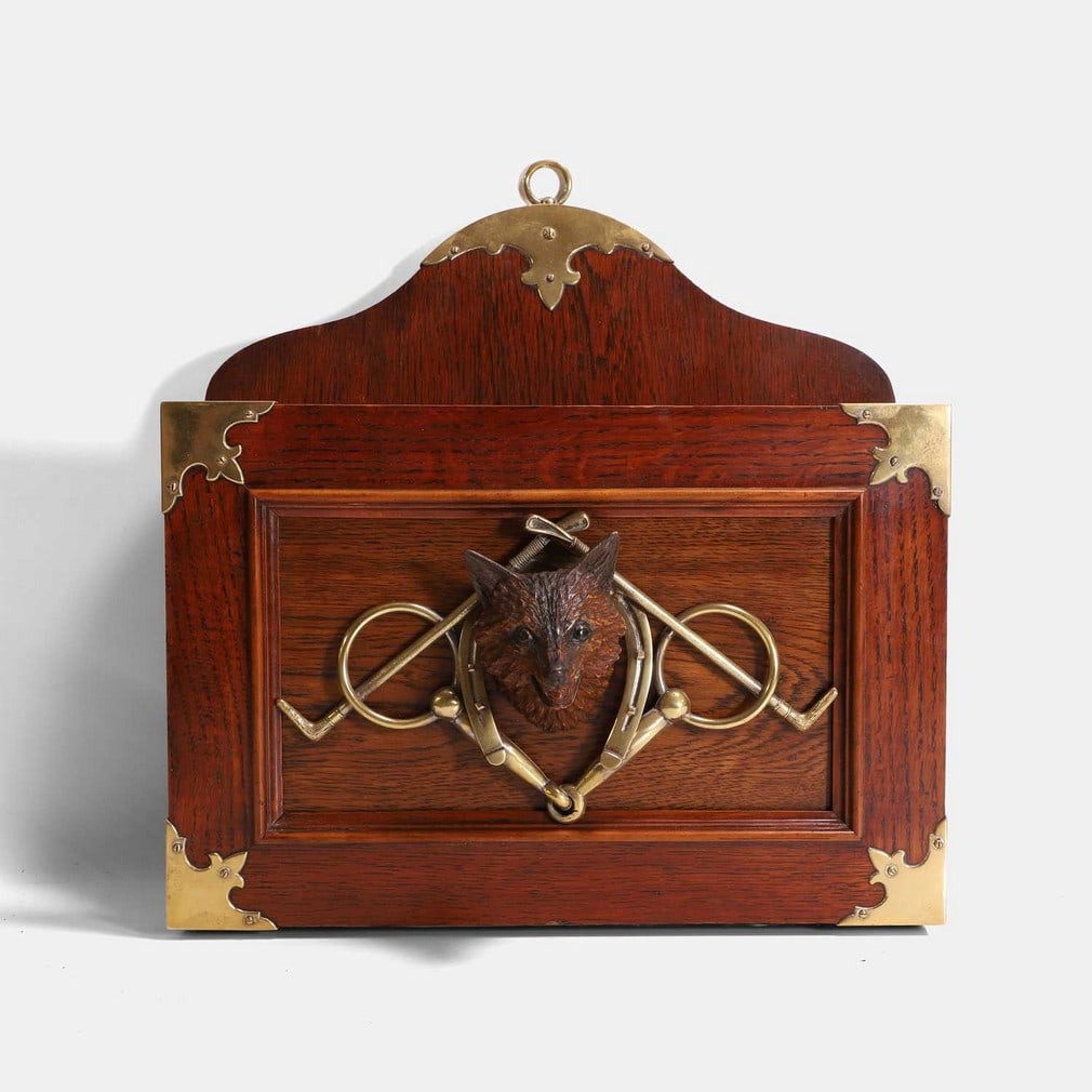 A novelty Victorian magazine or newspaper rack, late 19th century,: A novelty Victorian magazine or newspaper rack, late 19th century, mounted to the front with a fox head, horse bit, and riding crops (38cm wide, 12cm deep, 44cm high)