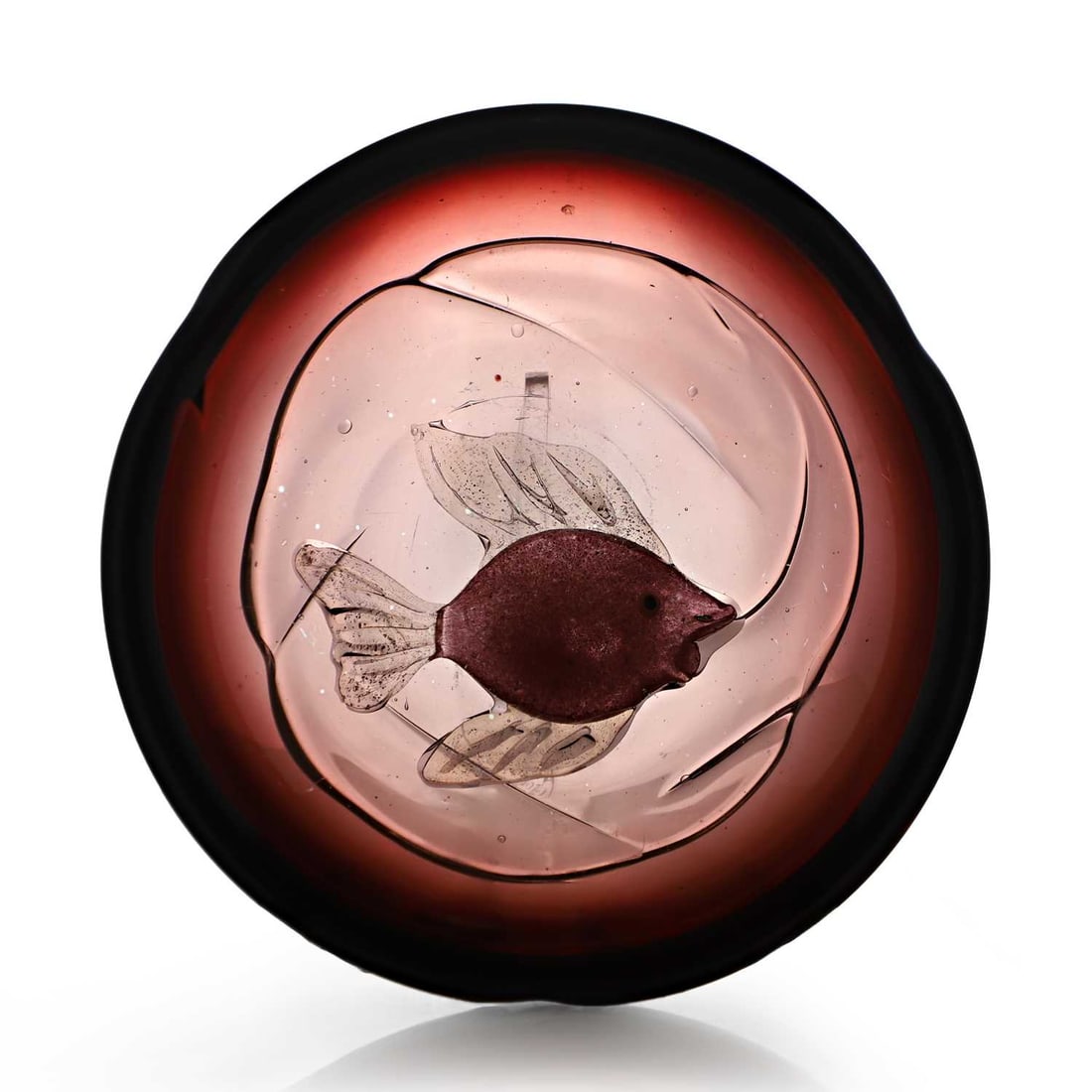 Alfredo Barbini (Italian, 1912-2007) a glass dish, circa 1960, Murano,: Alfredo Barbini (Italian, 1912-2007) a glass dish, circa 1960, Murano, of shallow form, inset with a fish decorated with aventurine inclusions, within a graduated amethyst ground 16.8cm diameter, 5cm