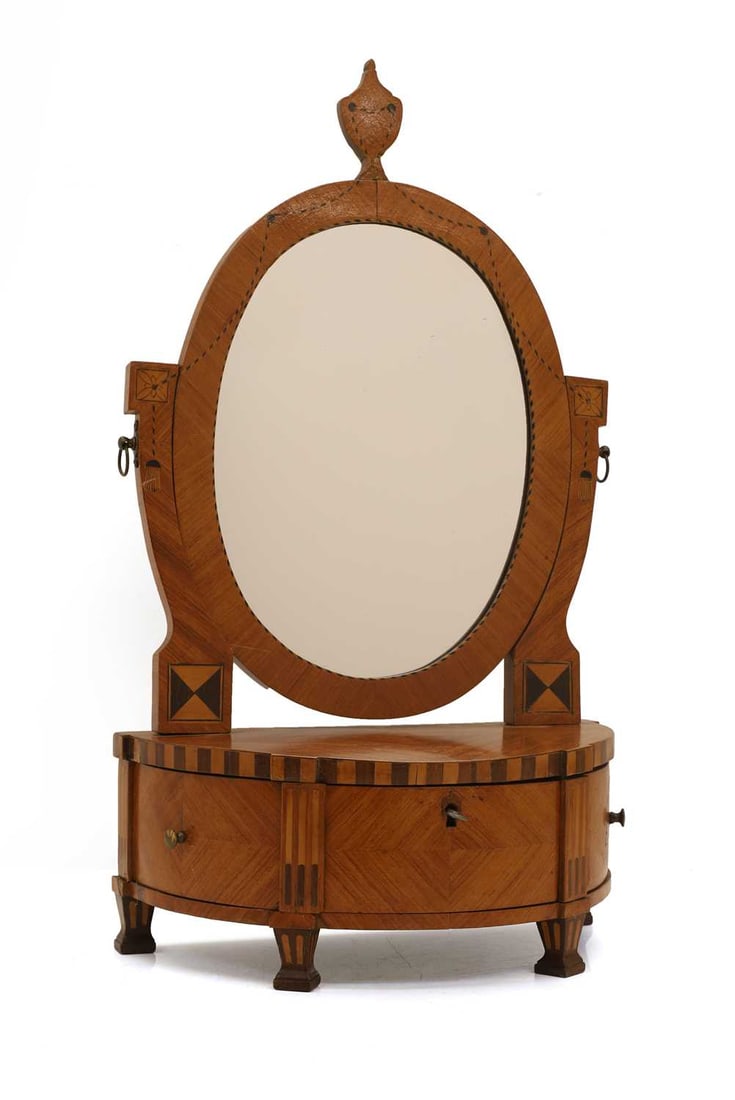 A demi lune satinwood table mirror, 19th century and later,: A demi lune satinwood table mirror, 19th century and later, the oval plate within a decorated border featuring inlaid swags, flanked by two curved supports with brass handles above the base with three