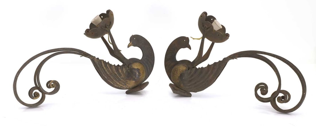 A pair of wrought iron Italian wall sconces, early 20th century,: A pair of wrought iron Italian wall sconces, early 20th century, in the form of a peacock, reclined holding a light fixture with its claws, with gilt detailing to chest, with outscrolled tail