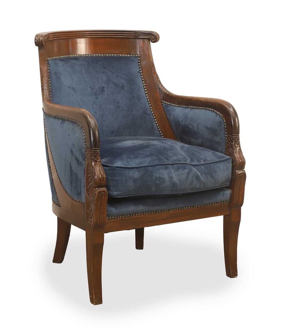 A French Empire mahogany gondola chair, 19th century,: A French Empire mahogany gondola chair, 19th century, with scrolled and fluted top rail above a dolphin motif carved to the lower arm, the body reupholstered in blue velvet Width 61.2cm, Depth 7