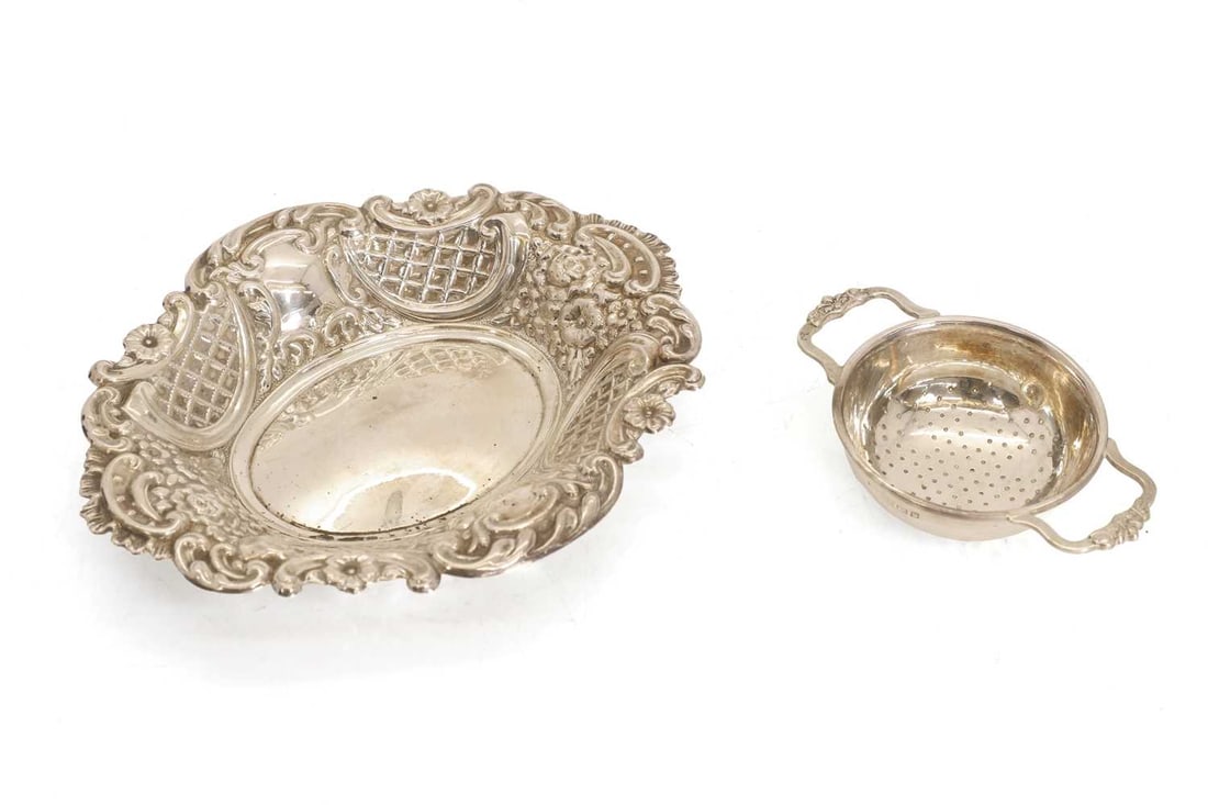 A silver repoussé dish,: A silver repoussé dish, by A Taite & Sons Ltd (probably), London, 1958, with floral decoration, together with a tea strainer, Birmingham, marks rubbed Dish, 6cm wide, 3.6ozt 2