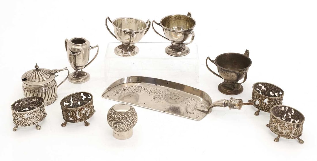 A small group of mixed silver pieces,: A small group of mixed silver pieces, to include four tri handled vessels, four matched salts without liners by Wilsdorf & Davis, Birmingham, 1897, a slice, a mustard pot and cover by IMB, Chester