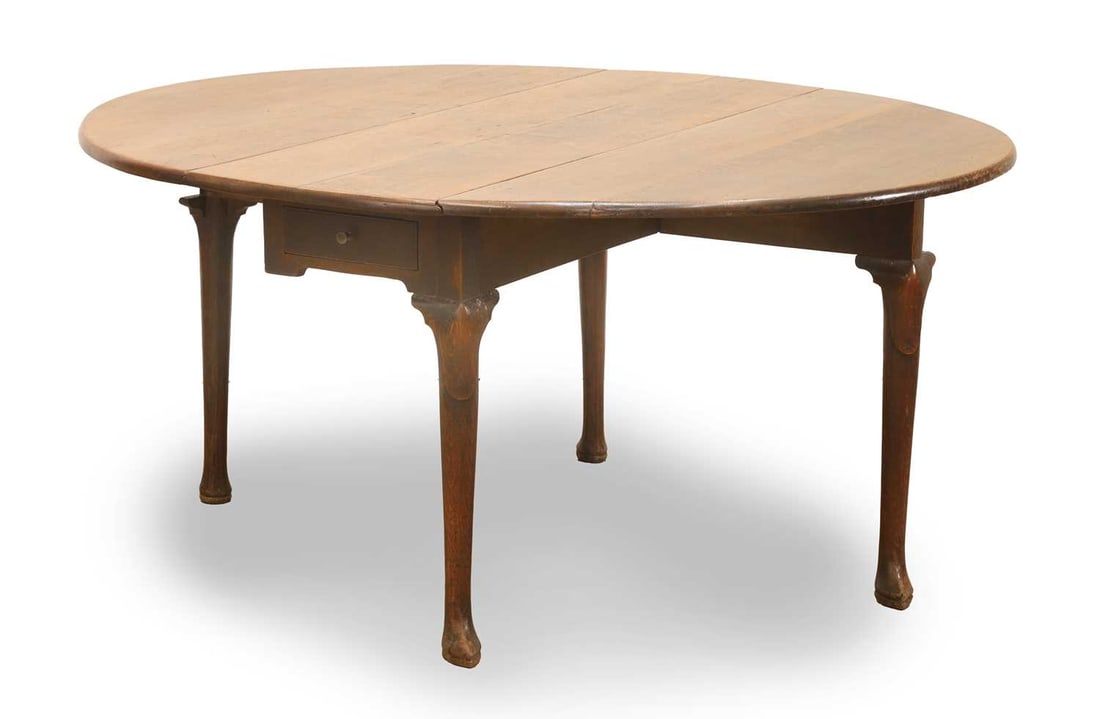 A George II oak drop flap table, mid 18th century,: A George II oak drop flap table, mid 18th century, on pointed pad foot supports, a single long drawer with single brass pull 128cm wide, 71cm high Condition Report: Some nibbling to the feet and possi